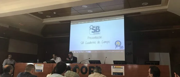 Ponentes en la mesa de Dcoop bajo la diapositiva Presentación SB Cuaderno de Campo, con el logotipo de SB Software