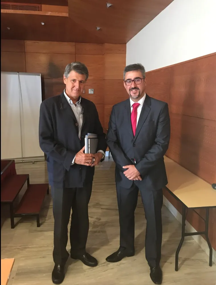 Representantes de Dcoop y de SB Software posan de pie, uno junto al otro, en una sala con paredes de madera