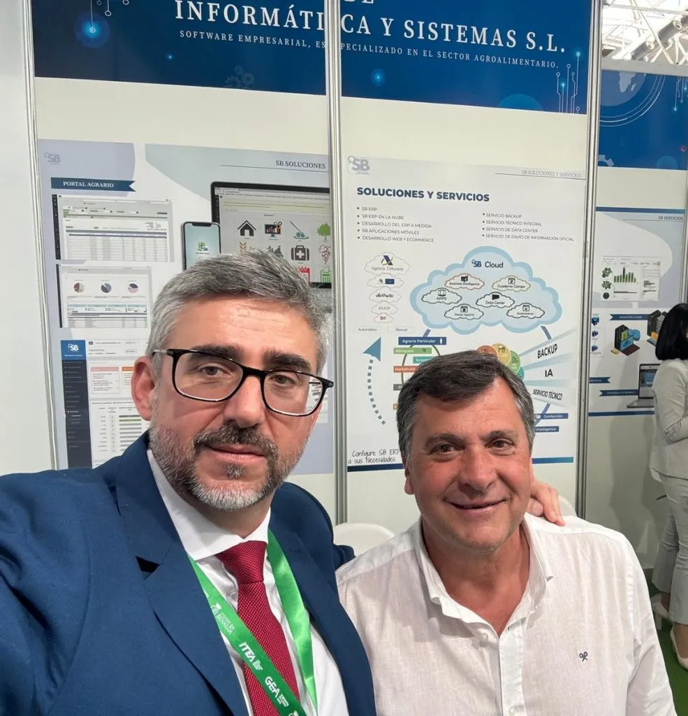 Dos hombres se hacen un selfi ante los paneles del portal agrario y de soluciones y servicios del stand